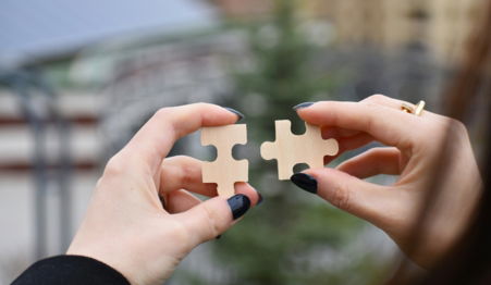 a few hands holding a small white object