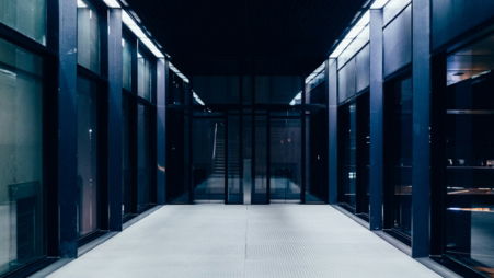 a long hallway with glass doors leading to another room