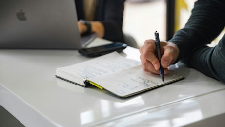 person writing on white paper